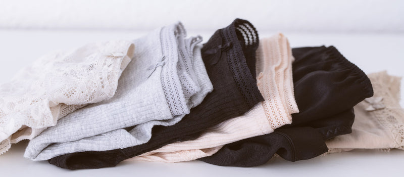 6 pairs of beautifully folded lace underwear in different colors like white grey, black and beige demonstrating the value of knowing how to fold underwear